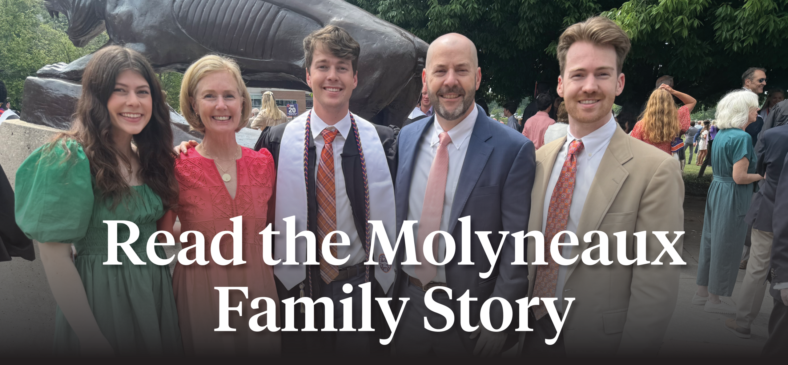 Four people smiling in front of Littlejohn Coliseum after Clemson's graduation.