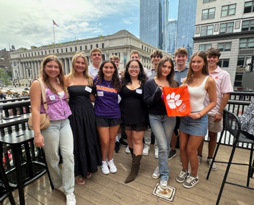 SSO-1 group of new students on a roof top with skyline behind holding a tiger rag