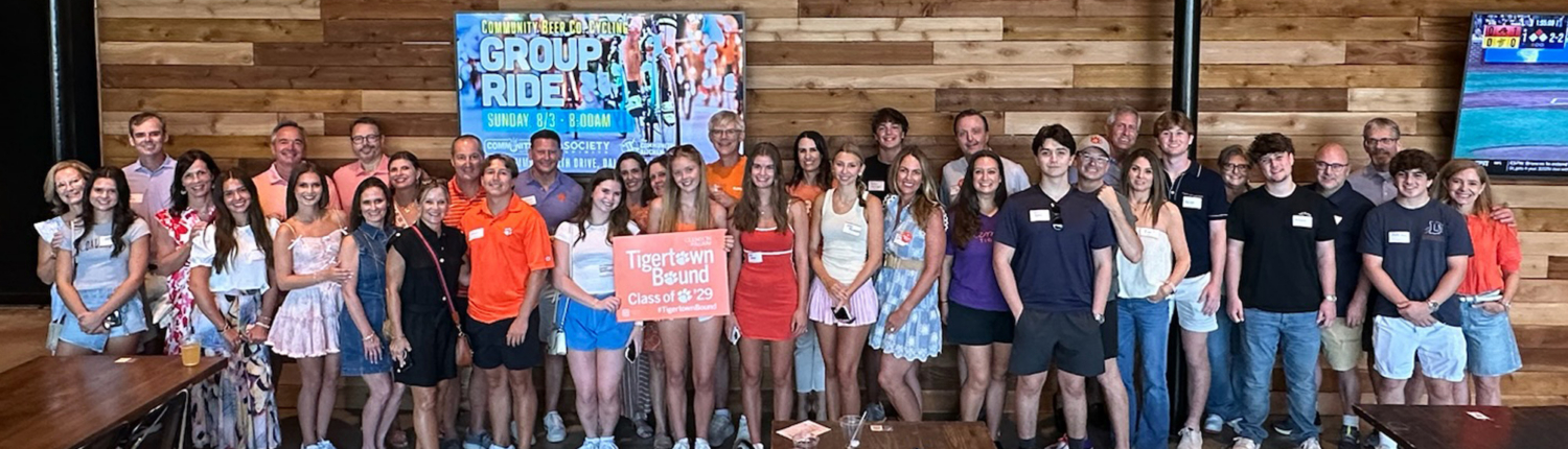 SSO-4 Group of new students at a send off party standing in front of a wooden wall